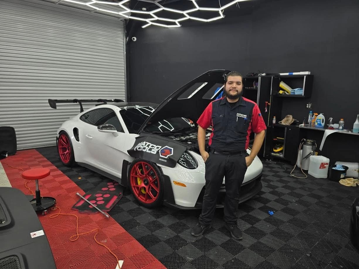 RP Euro Werks technician with white sports car in McAllen shop